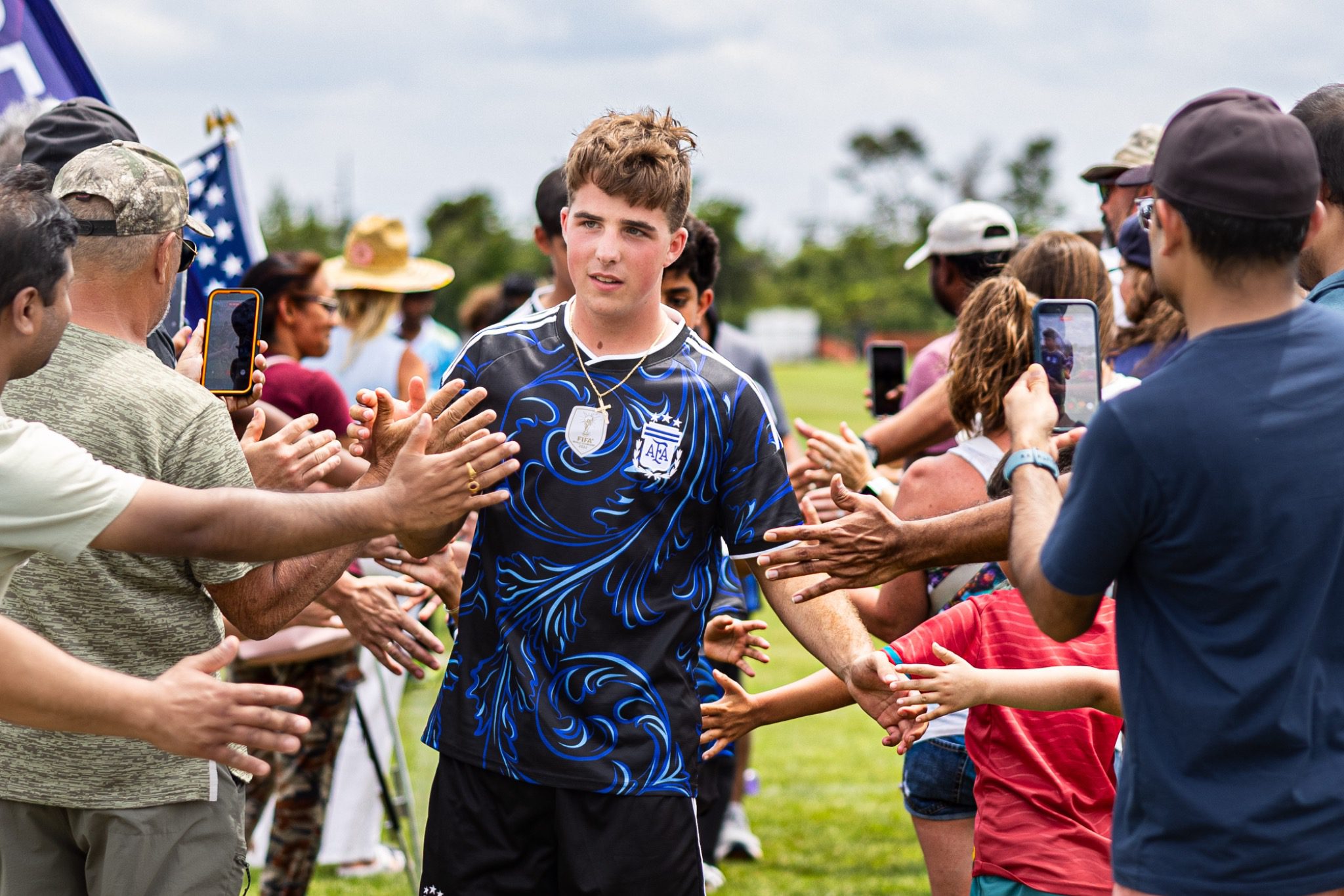 Youth soccer player walks through crowd of cheering fans at Deltona Youth Soccer Club Recreation World Cup 2026 Deltona Florida